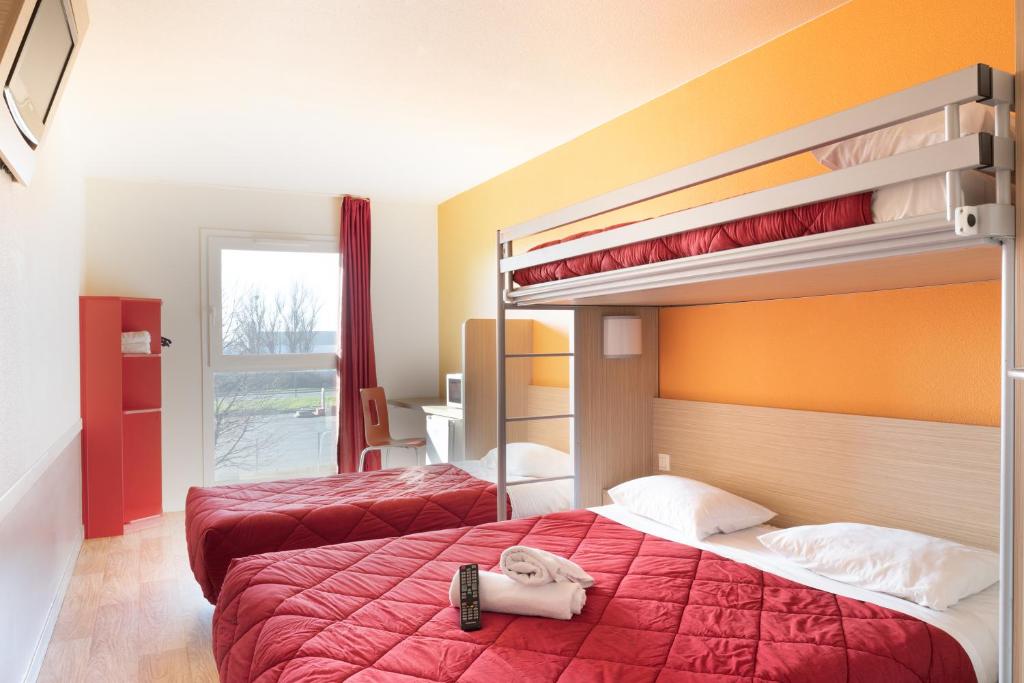 two beds in a room with two bunk beds at Premiere Classe Maubeuge in Feignies