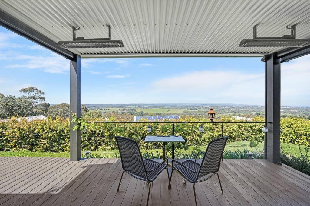 2 Stühle und ein Tisch auf einer Terrasse mit Aussicht in der Unterkunft Luxury & plush lifestyle 5 Bedroom house in Mt Eliza in Mount Eliza