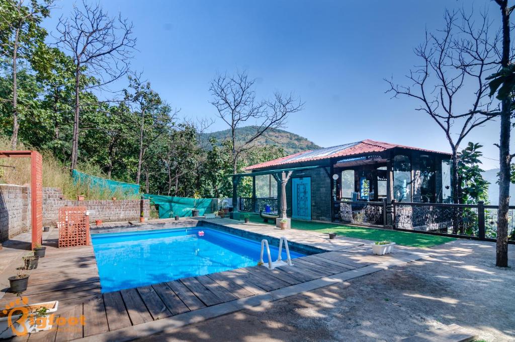 a house with a swimming pool and a gazebo at Ekayana Resorts and Agri Tourism, Mulshi in Pune