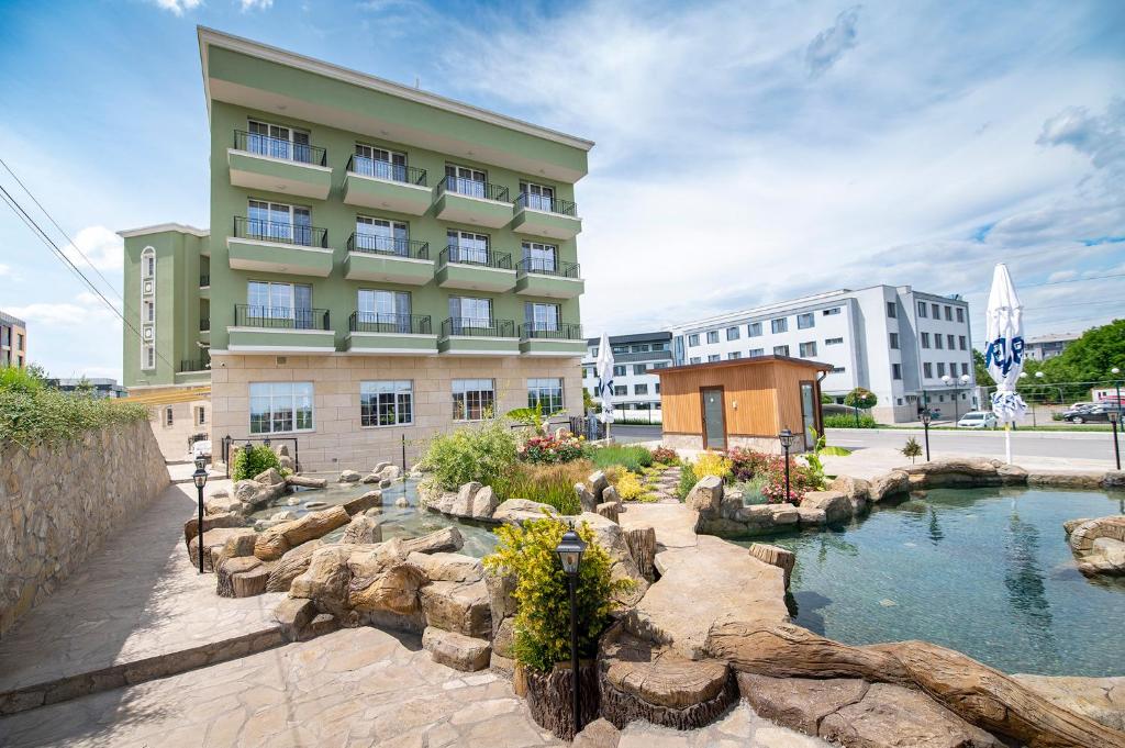 a hotel with a pond in front of a building at Хотел Глемпинг Алианс in Plovdiv