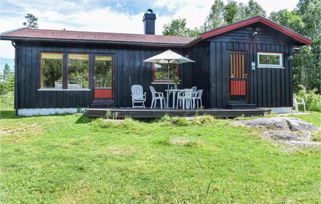 a black tiny house with a table and chairs at Stunning Home In Magnor With Kitchen in Magnor