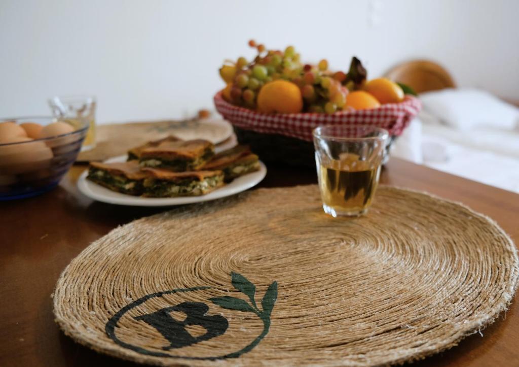 una mesa con un plato de comida y un bol de fruta en Birbas Hotel en Agia Anna Naxos