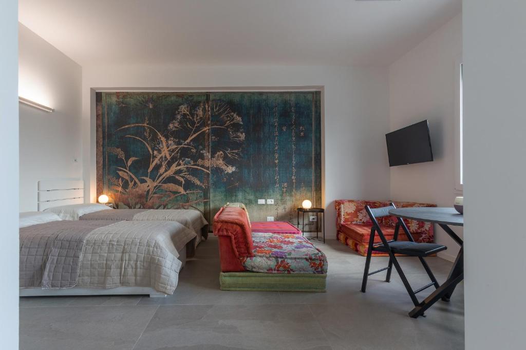 a bedroom with a bed and a table and a chair at Bologna Tecnopolo Utamaro apartment in Bologna