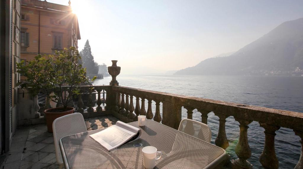 a table and chairs on a balcony overlooking the water at Terrazza Torno in Torno