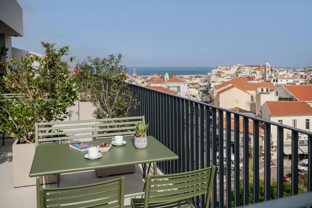 - Balcón con mesa verde y sillas en Arkadi Hotel, en La Canea