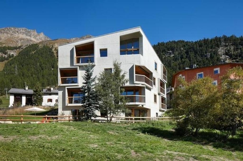 蓬特雷西納的住宿－Alpine Lodge 2-Bett-Wohnung Chesa Plattner "Bergbahnen All inklusiv" im Sommer，山顶上一座白色的大建筑