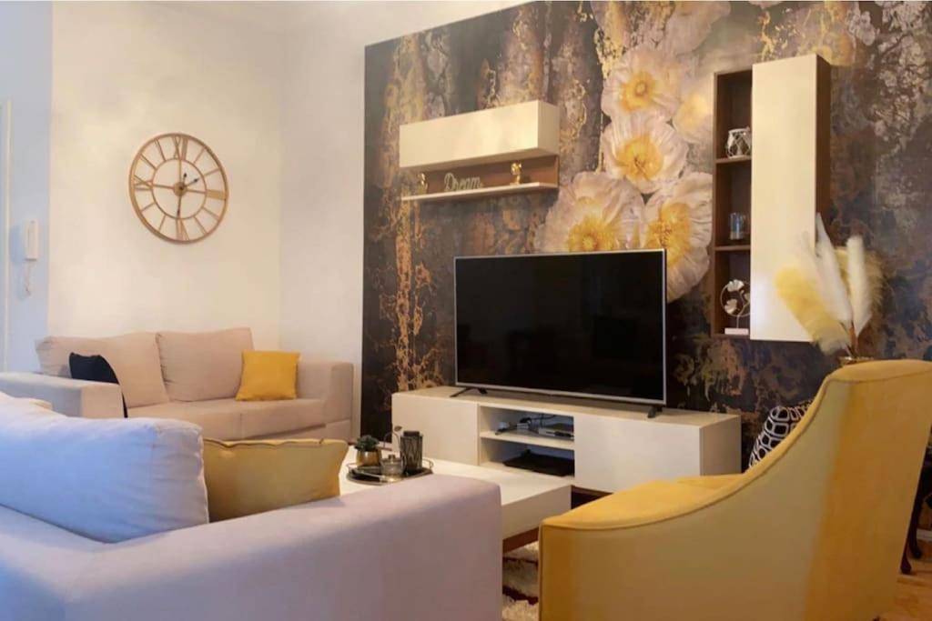 uma sala de estar com um sofá e uma televisão em Outstanding Two bedroom Apartment em Sahline