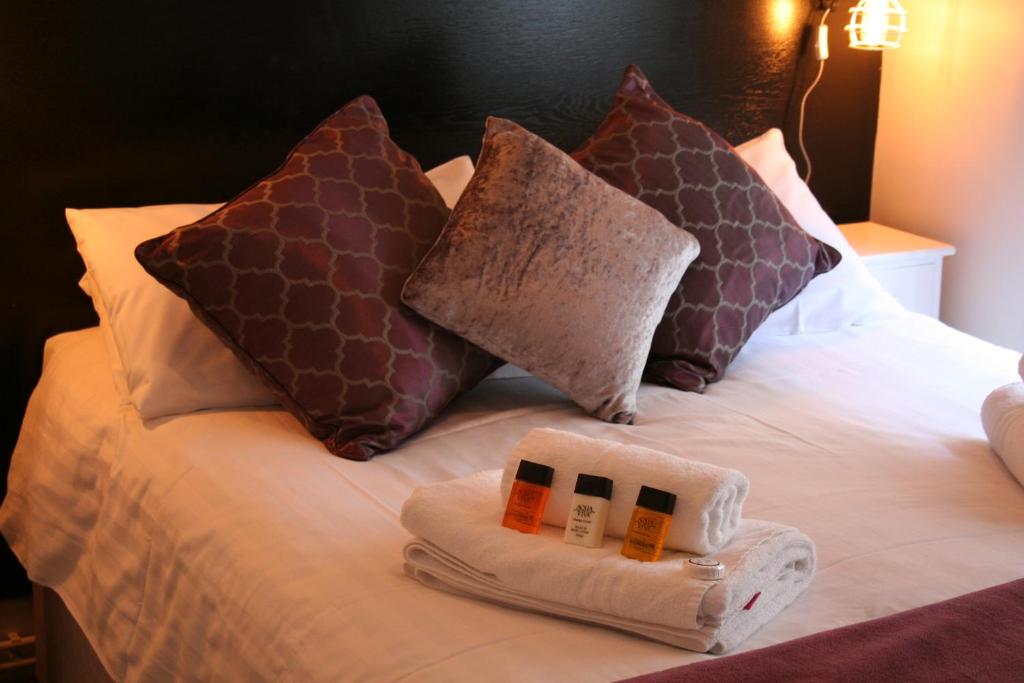 a bed with two towels and pillows on it at The Lady Elizabeth in Sudbury