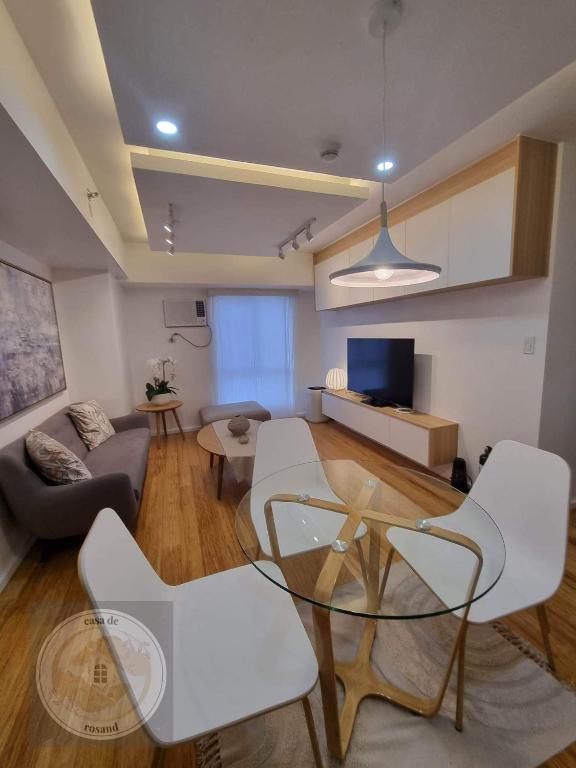 a living room with a glass table and white chairs at Casa de Rosand in Cebu City