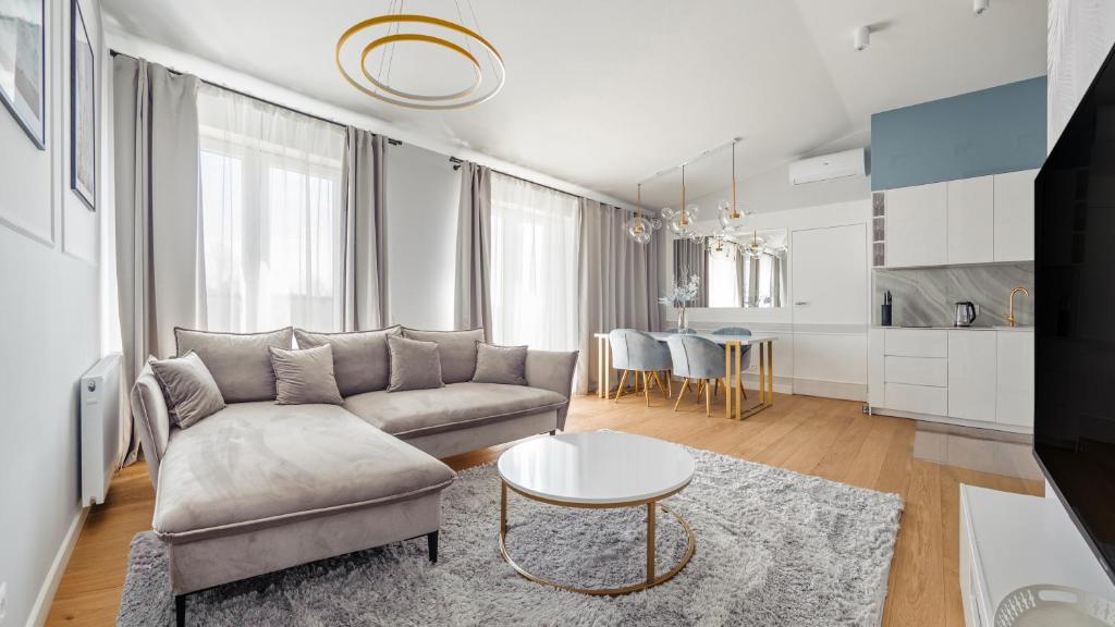 a living room with a couch and a table at Apartamenty Sun & Snow Rozewska Natura Park in Jastrzębia Góra