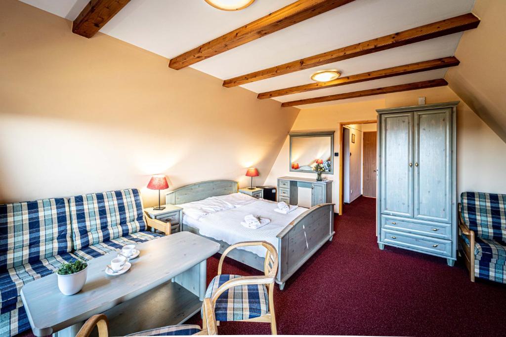 Cette chambre comprend un lit, une table et des chaises. dans l'établissement Hotel Sluníčko, à Ostravice