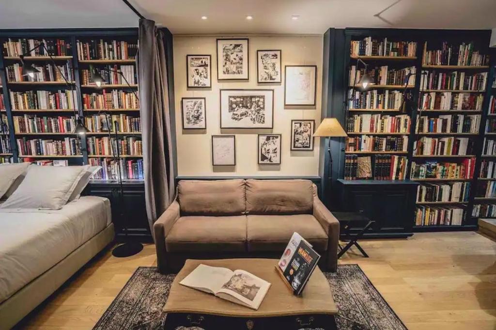 a living room with a couch and book shelves with books at Quartiers Enfants Rouges,Bretagne - Appartement d'architecte 4P in Paris