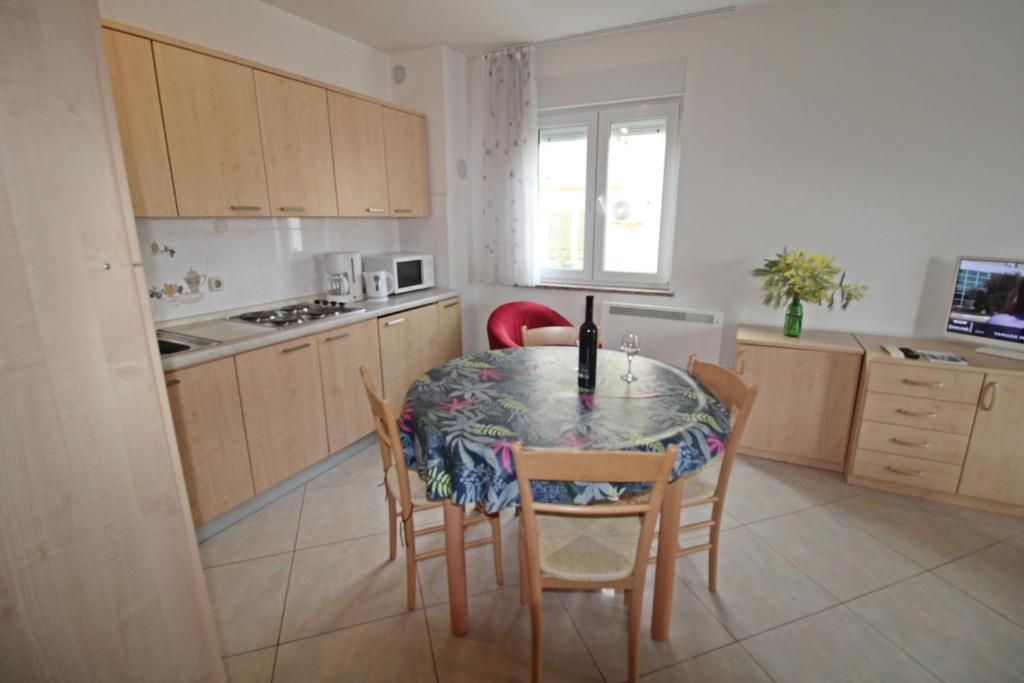 a kitchen with a table and chairs and a kitchen with a counter at Apartment Branka in Premantura