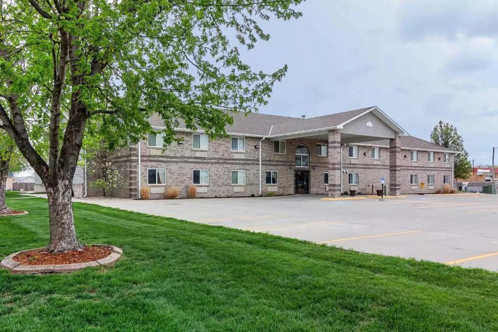 a large building with a tree in front of it at Rodeway Inn in Holdrege