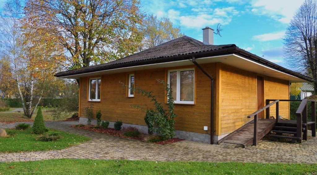 Cette petite maison en bois dispose d'une terrasse couverte et d'un escalier. dans l'établissement Apartamenty Lucky-ski, à Ustrzyki Dolne