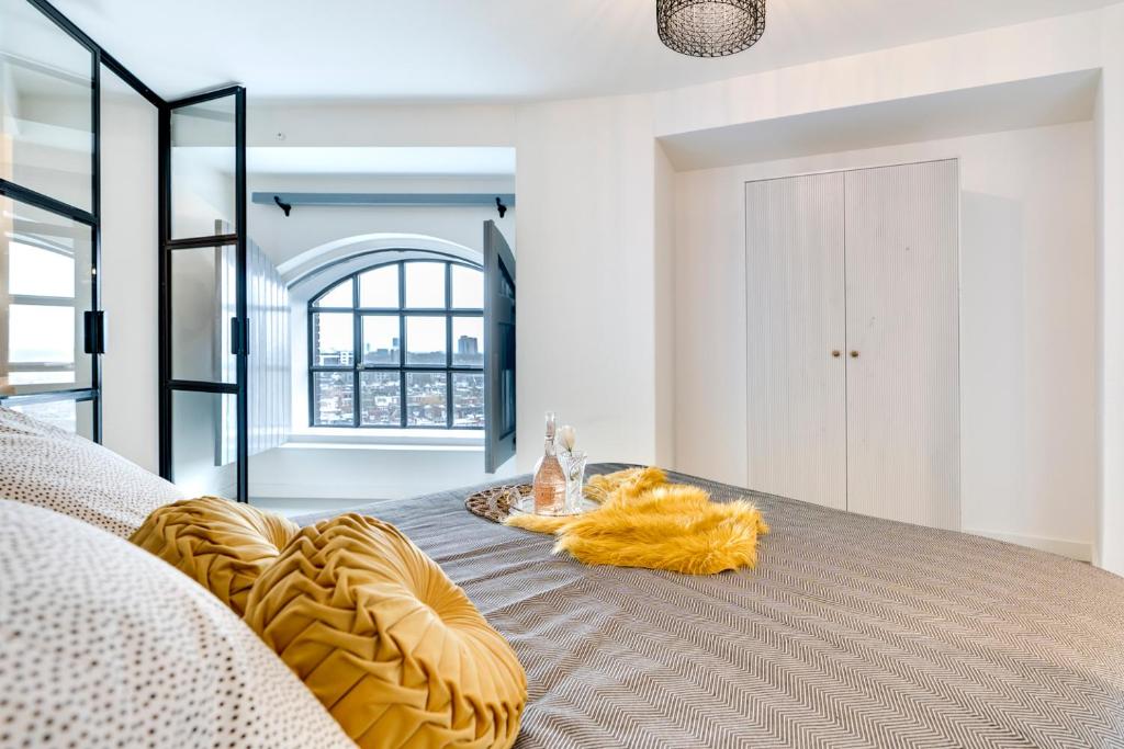 a bedroom with a bed with a yellow blanket on it at Hotel Watertoren West in Groningen