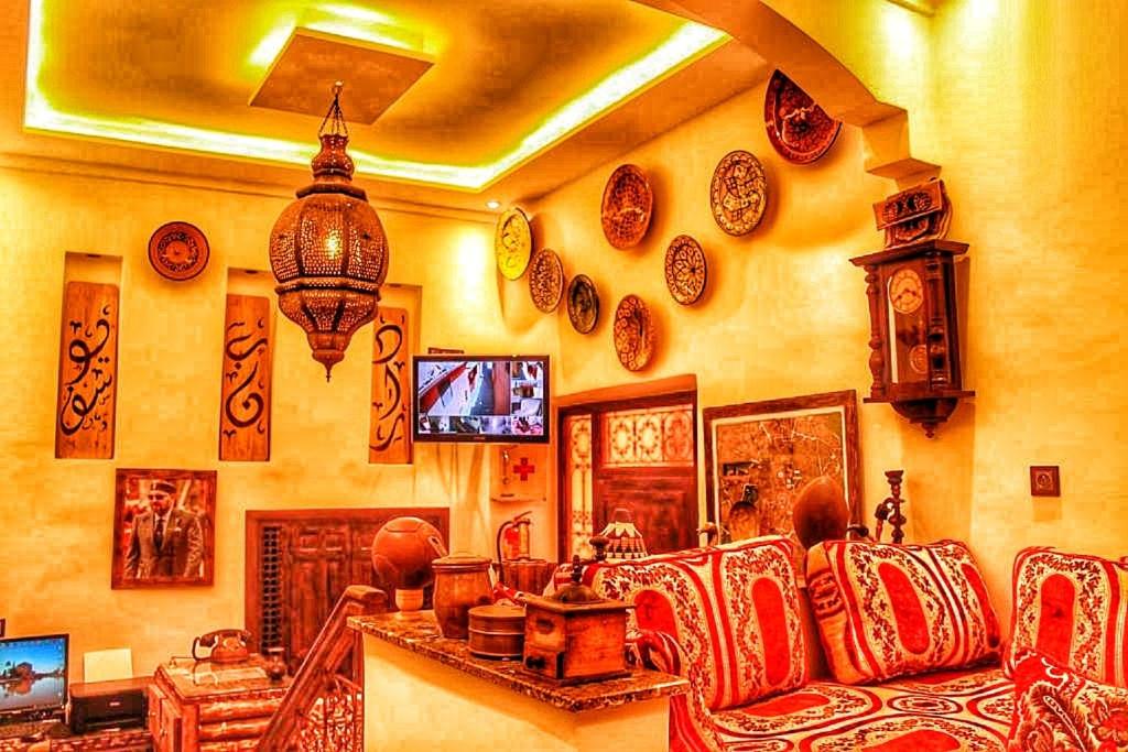 a living room with a couch and plates on the wall at Hostel Dar Ben Youssef in Marrakesh