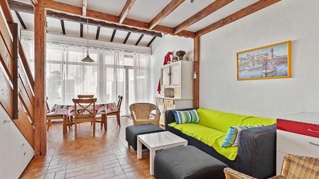 un salon avec un canapé vert et une table dans l'établissement Sun Village- 59- Maison spacieuse- 4 pers, au Cap d'Agde