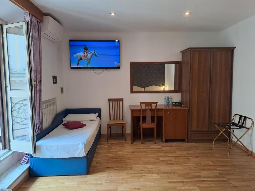 a bedroom with a bed and a tv on the wall at Hotel Fenicia in Rome