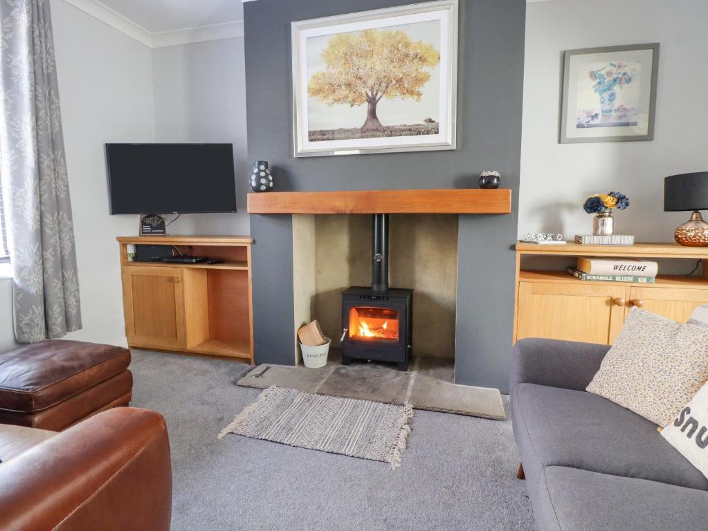 a living room with a fireplace and a couch at 15 Clitheroe in Skipton
