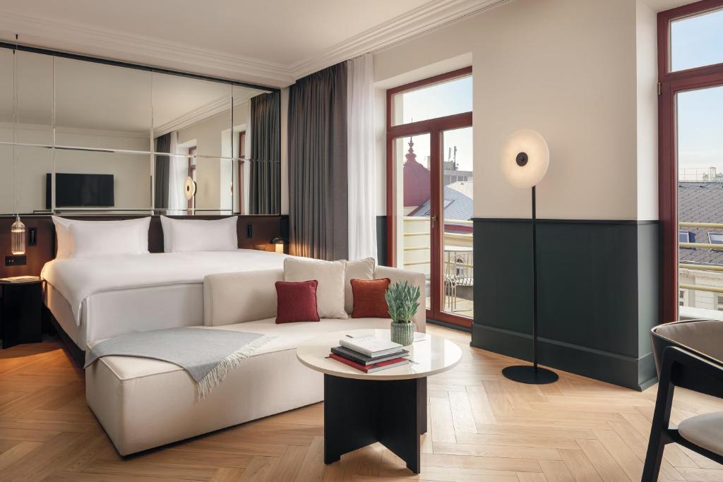 Habitación de hotel con sofá y cama en Almanac X Alcron Prague, en Praga