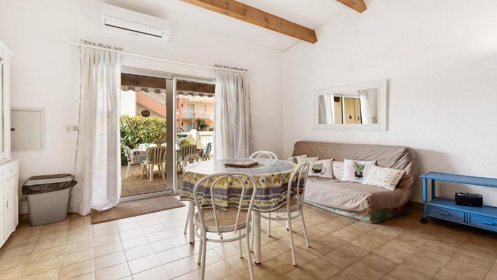 a living room with a table and a couch at Cristallines- 89- Maison mezzanine- 6 pers in Cap d'Agde