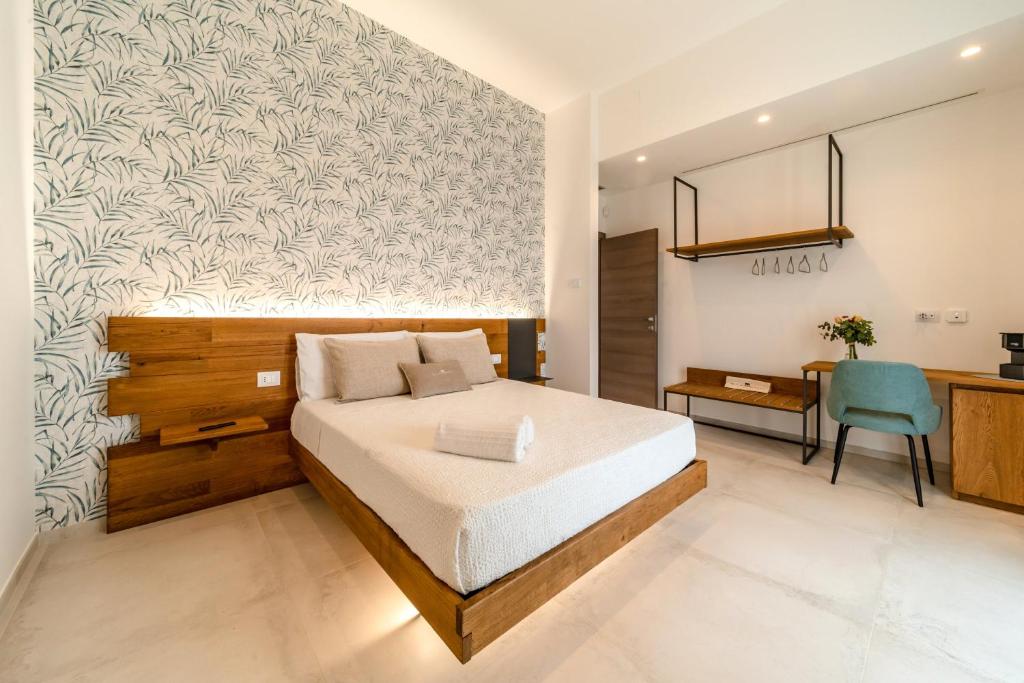1 dormitorio con cama, escritorio y silla en Sarmenti Agriresort, en Otranto