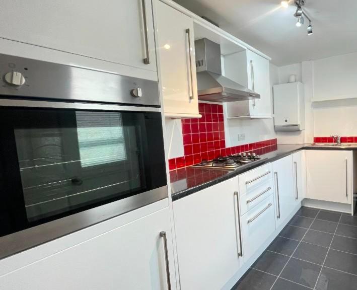 a kitchen with white cabinets and red tiles at Family friendly home Saltburn with Seaview in Skelton