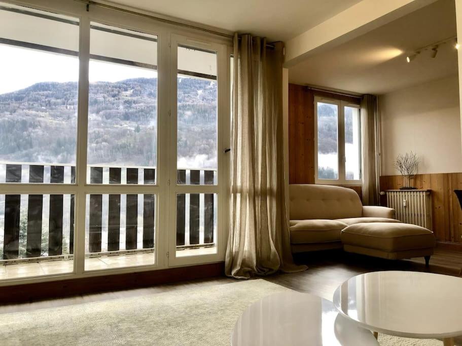 salon z kanapą i dużymi oknami w obiekcie Apartment Bourg St Maurice w mieście Bourg-Saint-Maurice