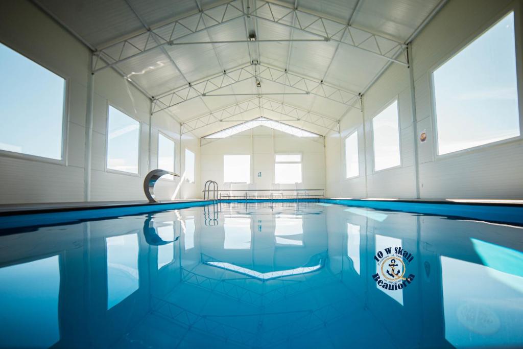 a swimming pool with blue water in a building at 10 w skali Beauforta in Rusinowo