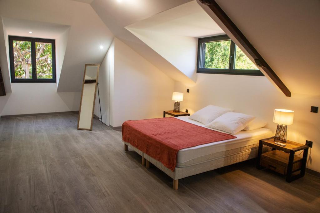 1 dormitorio con 1 cama con 2 mesas y 2 ventanas en Villa des 3 sables, MACABI en Étang-Salé les Bains