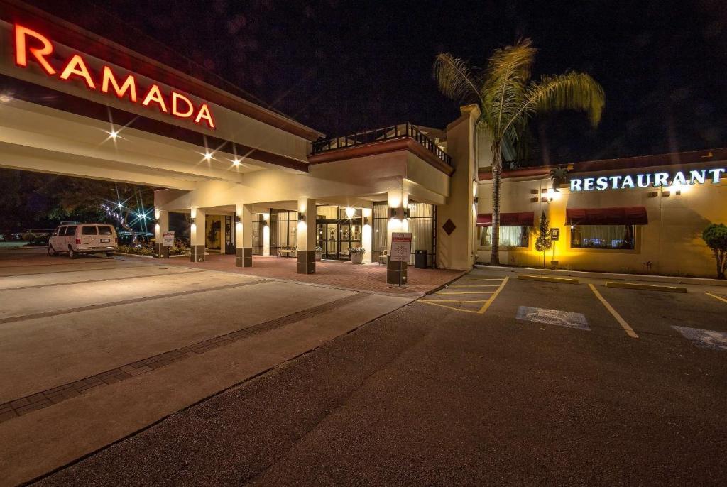 an empty parking lot in front of a hotel at night at Ramada by Wyndham Houston Intercontinental Airport East in Humble