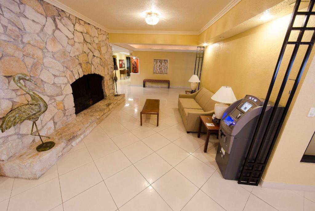 a living room with a stone fireplace and a couch at Ramada by Wyndham Houston Intercontinental Airport East in Humble