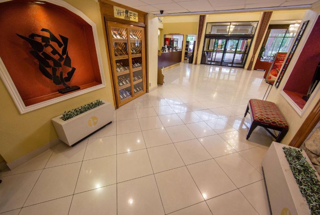 a hallway with a tile floor in a building at Ramada by Wyndham Houston Intercontinental Airport East in Humble
