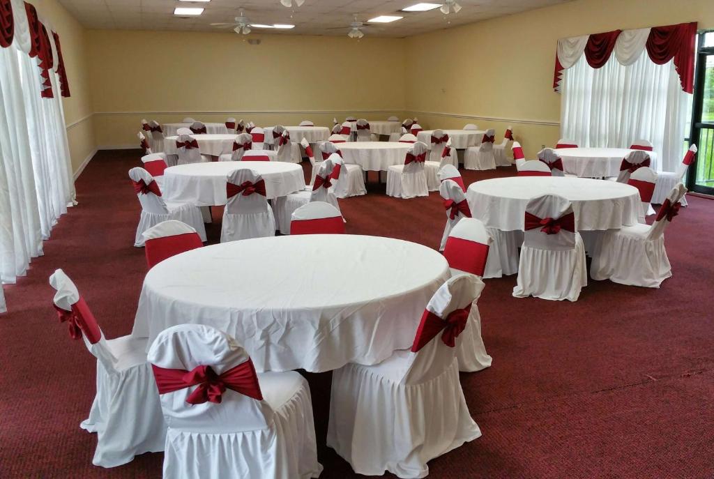 a room with white tables and chairs with bows at Ramada by Wyndham Houston Intercontinental Airport East in Humble