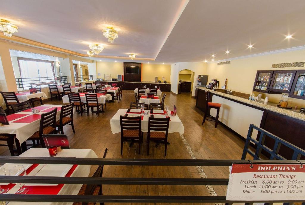 a restaurant with tables and chairs and a bar at Ramada by Wyndham Houston Intercontinental Airport East in Humble