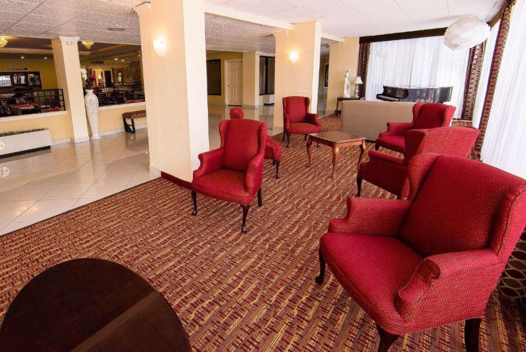 a waiting room with red chairs and a counter at Ramada by Wyndham Houston Intercontinental Airport East in Humble