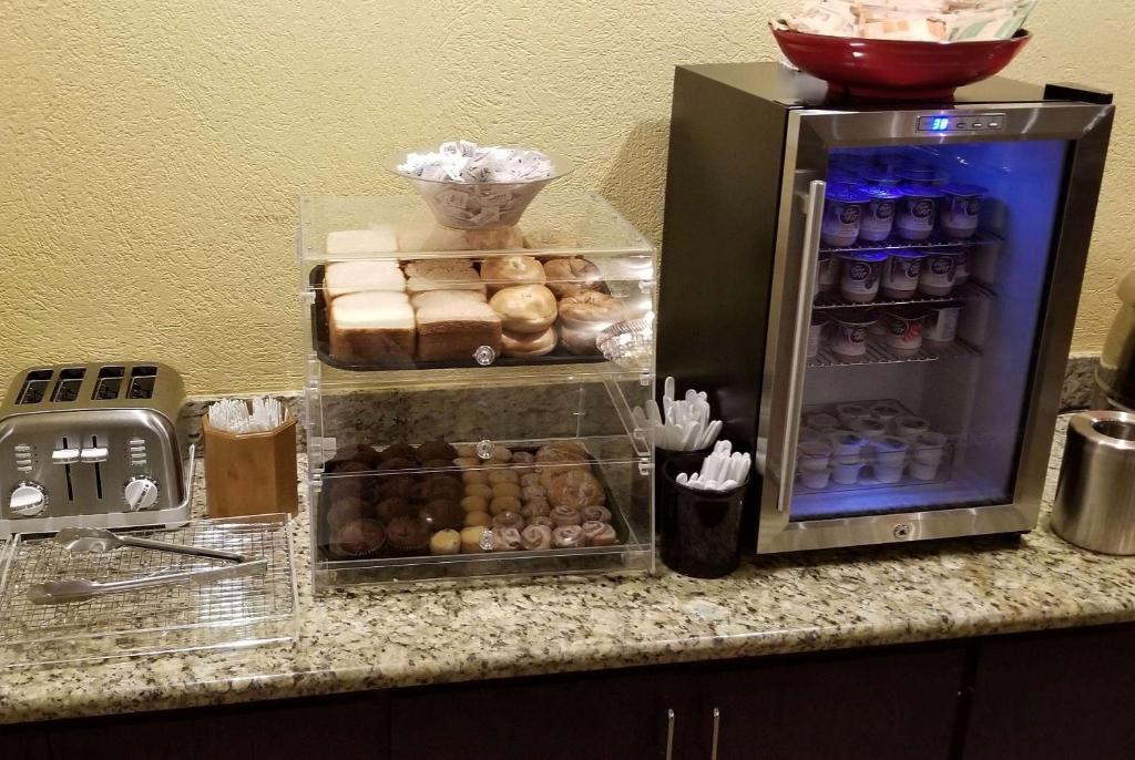 a counter with a refrigerator filled with lots of donuts at Ramada by Wyndham Houston Intercontinental Airport East in Humble