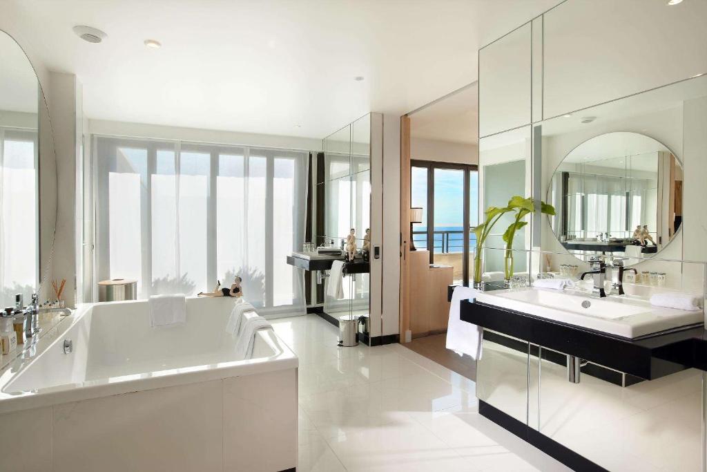 La salle de bains est pourvue d'une baignoire, de 2 lavabos et d'un miroir. dans l'établissement Hyatt Regency Nice Palais de la Méditerranée, à Nice