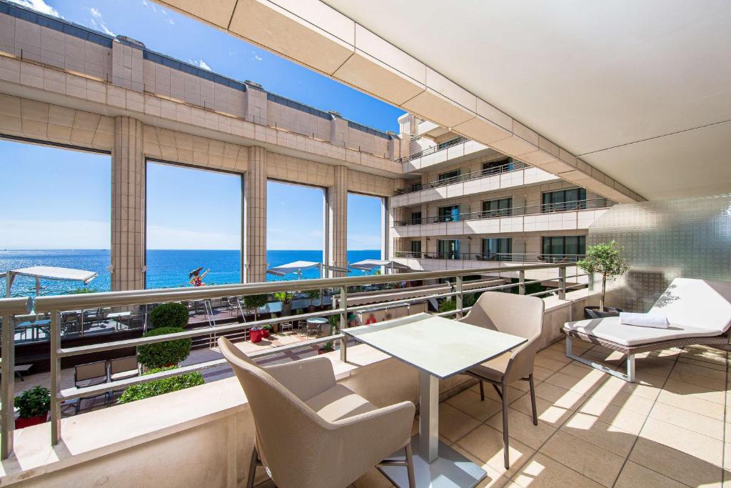 a balcony with a table and chairs and a view of the ocean at Hyatt Regency Nice Palais de la Méditerranée in Nice