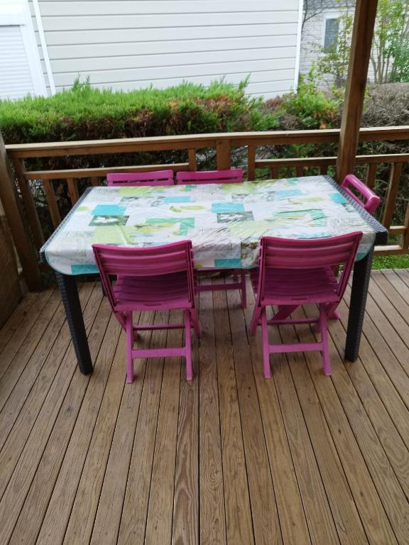 a table and four chairs on a deck at mobil home lac des reves in Lattes