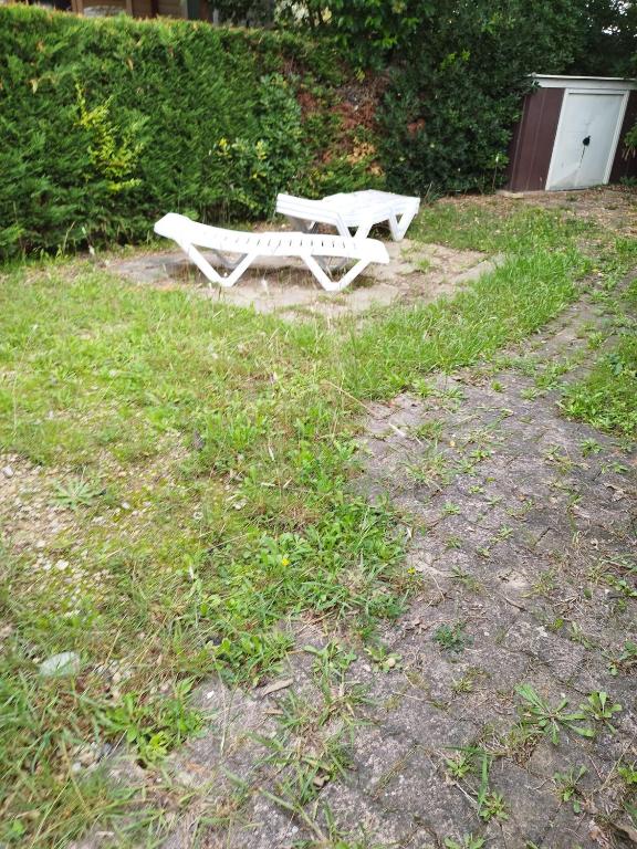 a white bench sitting in a field of grass at mobil home lac des reves in Lattes