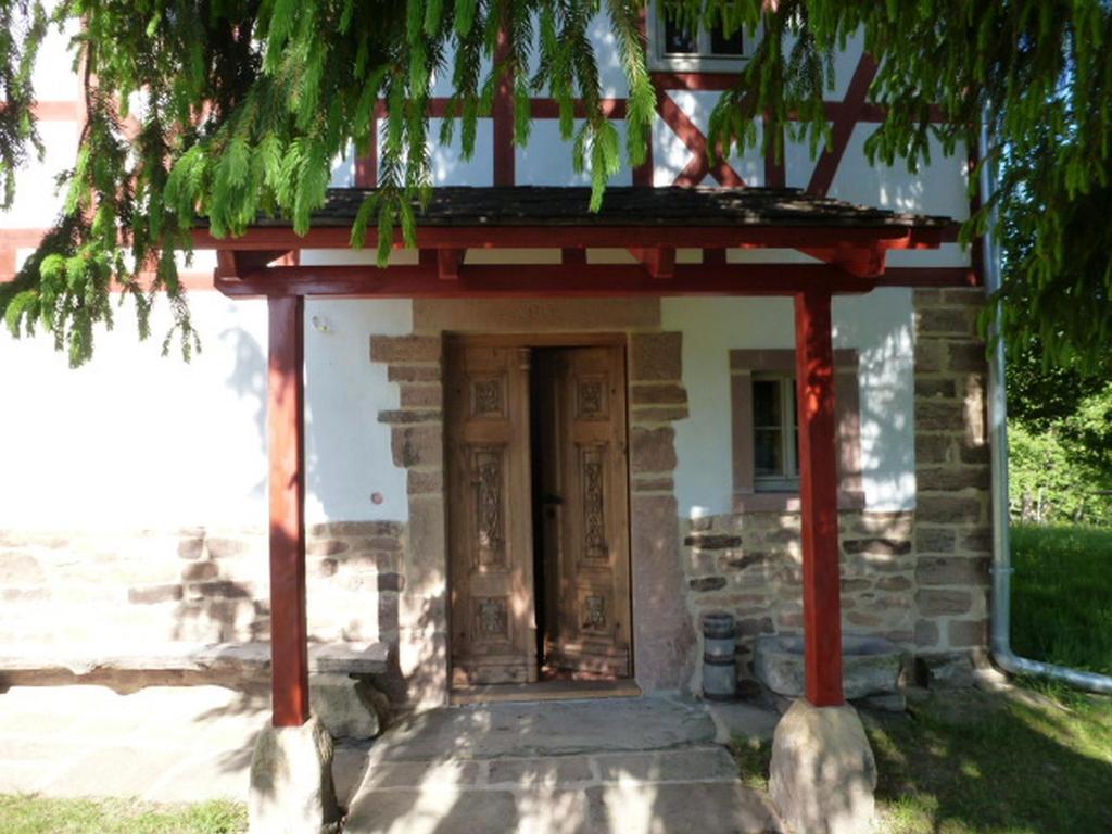 una entrada a un edificio de piedra con porche en Cottage Das kleine Glück, en Rosendorf