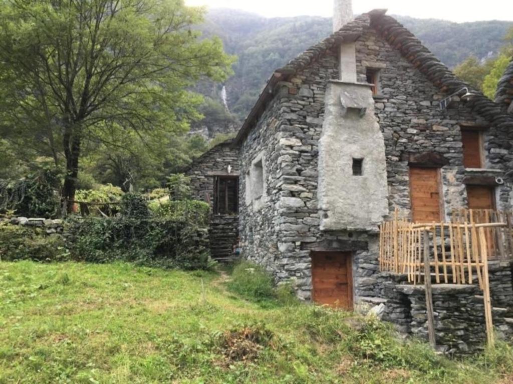 stary kamienny dom na zboczu wzgórza w obiekcie Rustico Ca'd'Damunt w mieście Cevio