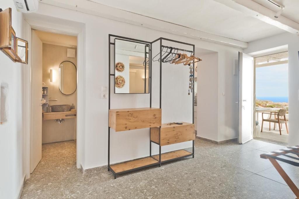 una habitación con espejo y un estante con comida. en Blé - Traditional Renovated Cottage en Afiartis