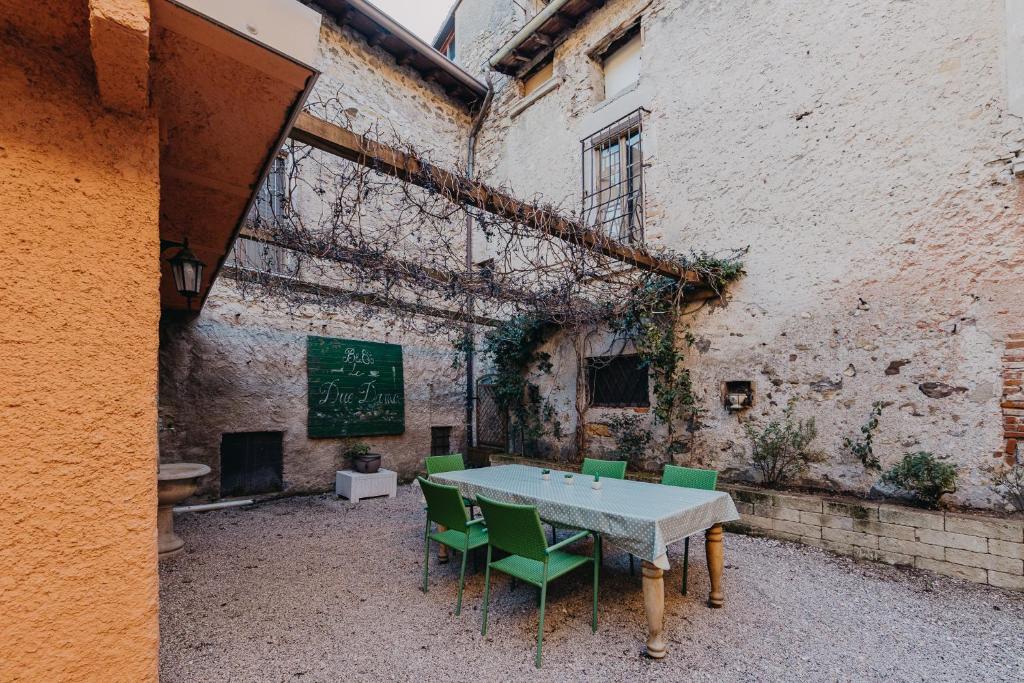 un tavolo e sedie in un vecchio edificio di Le Due Dame a Manerba del Garda