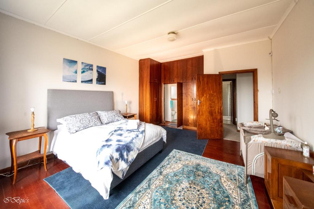 a bedroom with a bed and a table and a desk at Bella@Jbay in Jeffreys Bay