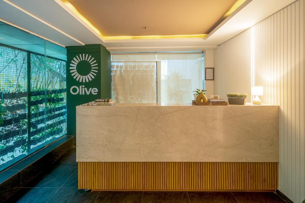 an office with a counter with a sign on it at Olive MG Road Dunsvirk Inn - by Embassy Group in Bangalore