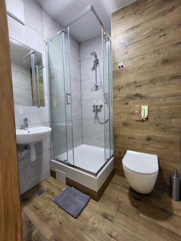 a bathroom with a shower and a toilet and a sink at FOKA Hostel in Wrocław
