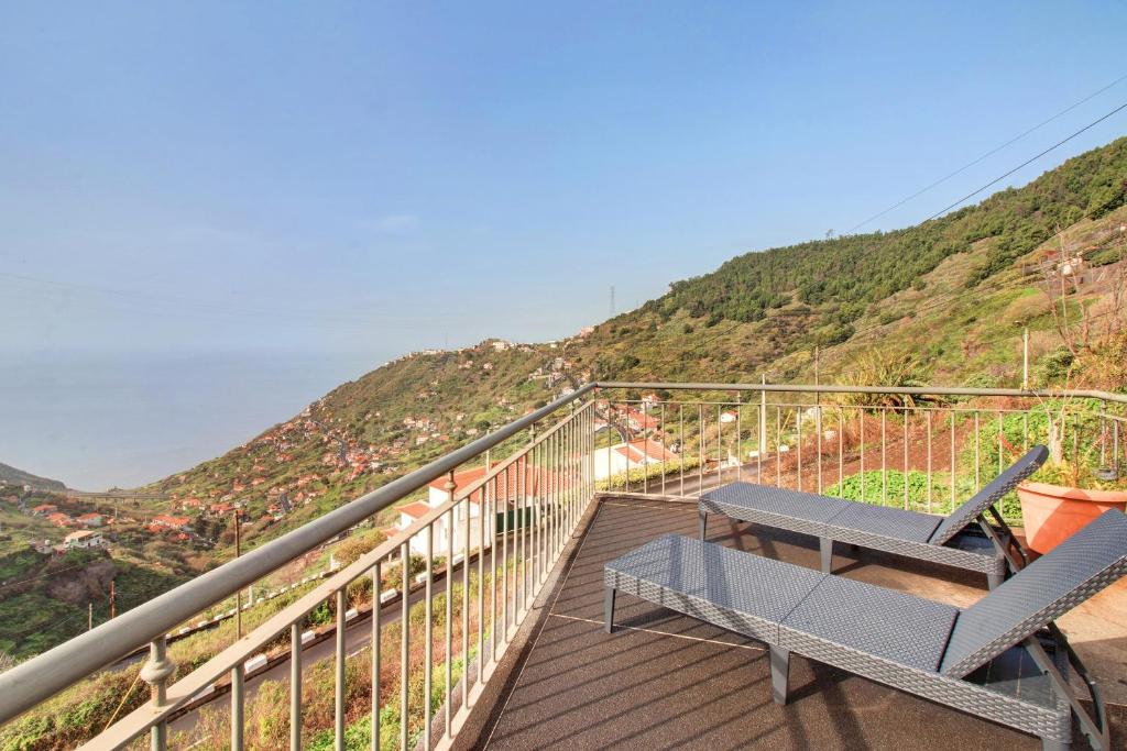 a balcony with a bench and a view of a mountain at Madeira Villa Liliana in Campanário
